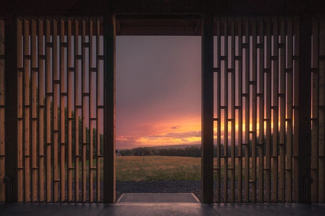 Sunset over the fields, seen through the open doorway of the Gather Greene pavilion